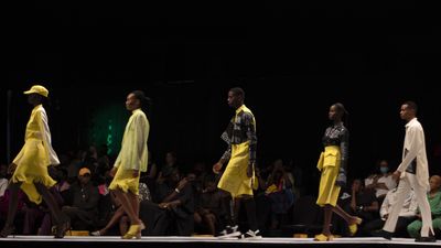 An image of five models walking the catwalk, dressed in yellow outfits