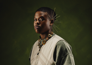 Nasty C poses for the camera, hands inside his jacket.