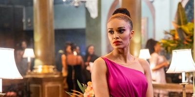 Pearl Thusi as Queen Sono in a pink dress and a fancy setting.