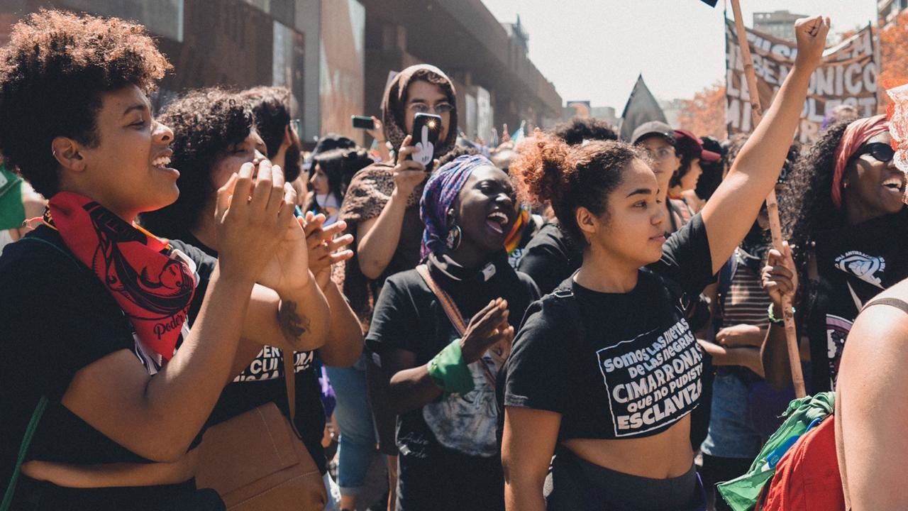 Black Chilean feminists marching with raised fists