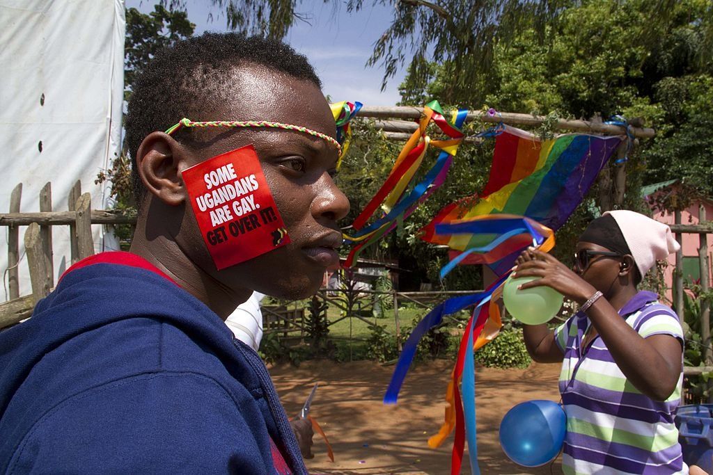 Photo of a Ugandan activist with a sticker that says, "Some Ugandans Are Gay. Get over it!"