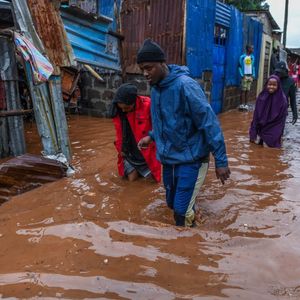 Residents are seen in a flooded street of Mathare neighborhood after heavy rains as they try to evacuate the area with their important belongings in Nairobi, Kenya on April 24, 2024.