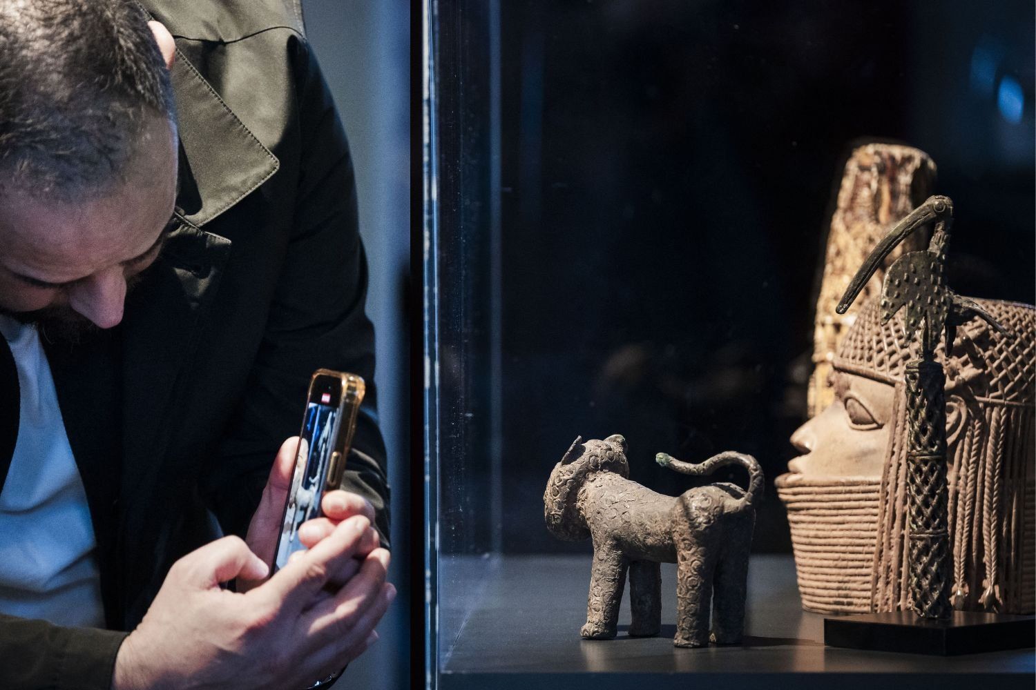 A person takes a photograph of a glass case containing some of the 113 Benin Bronzes that are being returned to Nigeria after British troops looted them in the late 19th century, during a handing over ceremony at the Wereldmuseum (World Museum) in Leiden on February 19, 2025. 