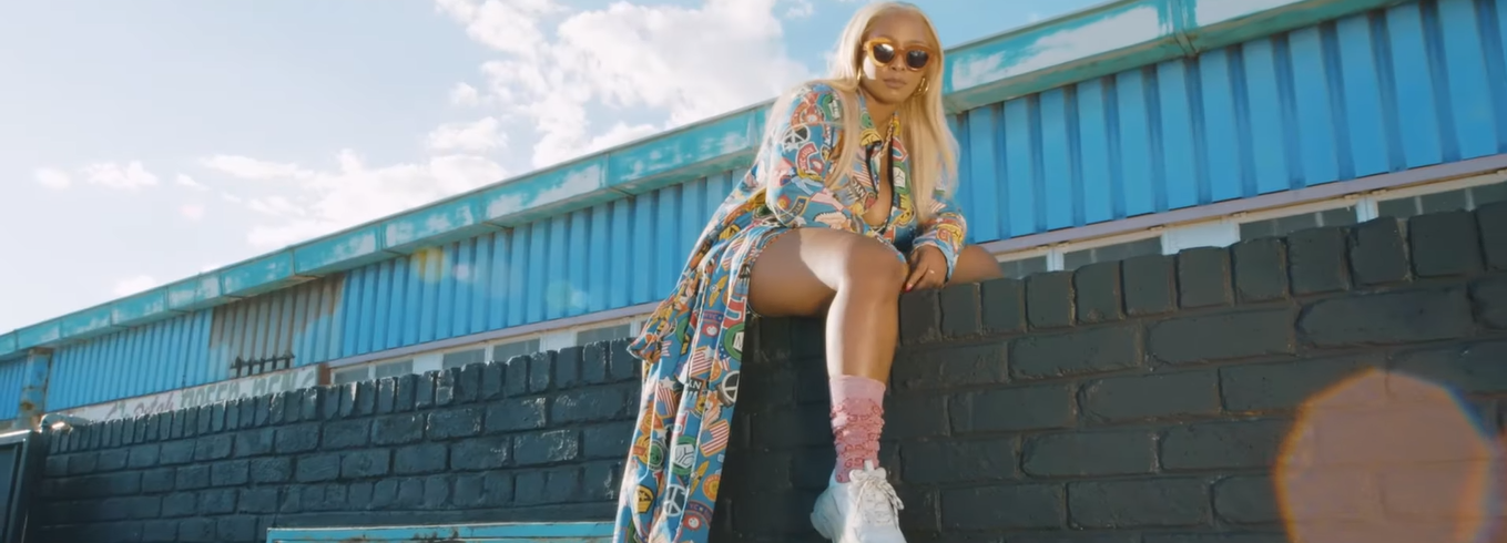 South African rapper Boity sitting on a wall.