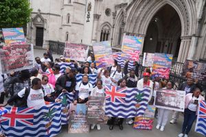 A group of Chagossians protest outside the Royal Courts of Justice in London, holding BIOT flags and placards demanding UK citizenship and denouncing the Mauritian government over historical injustice and human rights violations.