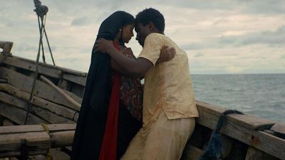 A still from the film of a man and woman holding each other on a boat