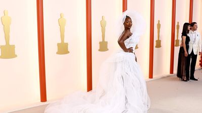 An image of the singer Tems on the Academy Awards’ red carpet wearing a spectacular white ensemble that goes over her head.