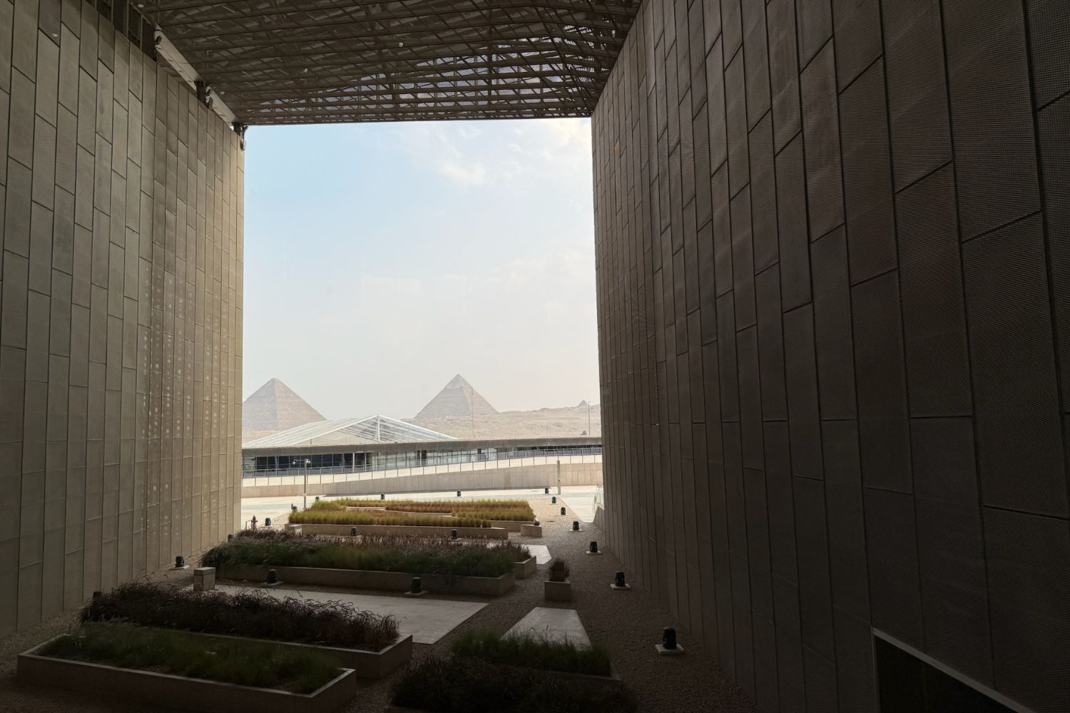 View of the Great Pyramids of Giza from the Grand Egyptian Museum, through a panorama window. 