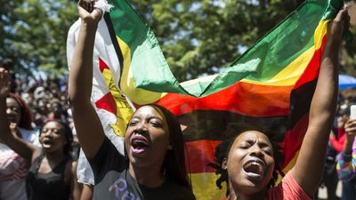 Women holding a flag of Zimbabwe take part in a demonstration of University of Zimbabwe's students, on November 20, 2017 in Harare, to demand the withdrawal of Grace Mugabe's doctorate and refused to sit their exams as pressure builds on Zimbabwe's President Robert Mugabe to resign.