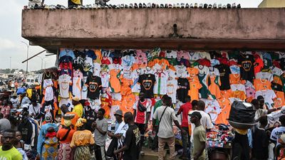 An image of vendors selling football kits at a market stall in Abidjan ahead of the 2024 Africa Cup of Nations.