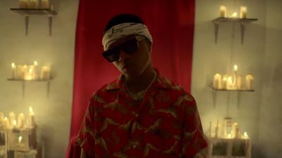 Wizkid posing in the 2019 music video for his hit Joro wearing a red shirt and a headband.