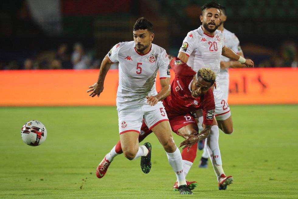 Madagascar's Lalaina Nomenjanahary (C) and Tunisia's Oussama Haddadi (L) battle for the ball during the 2019 Africa Cup of Nations quarter final soccer match between Madagascar and Tunisia at the Al-Salam Stadium.