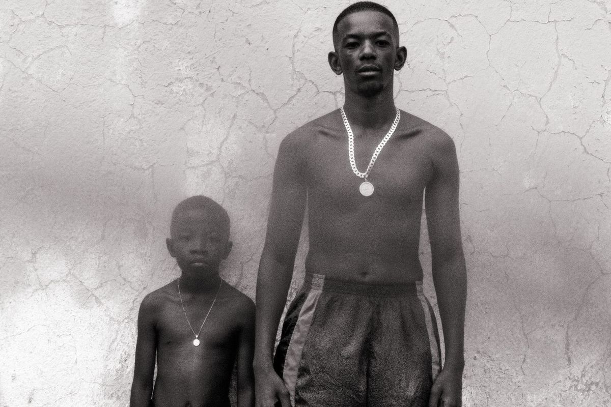 Maglera Doe Boy poses with his nephew, Lonwabo, who appears in the video. They are both topless, and both wear chains on their necks.