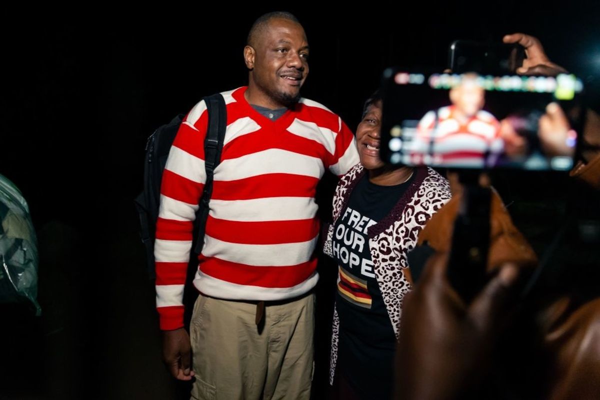 Man dressed in red and white striped jersey embraced by woman 