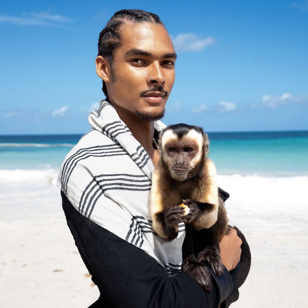 man on beach holding monkey