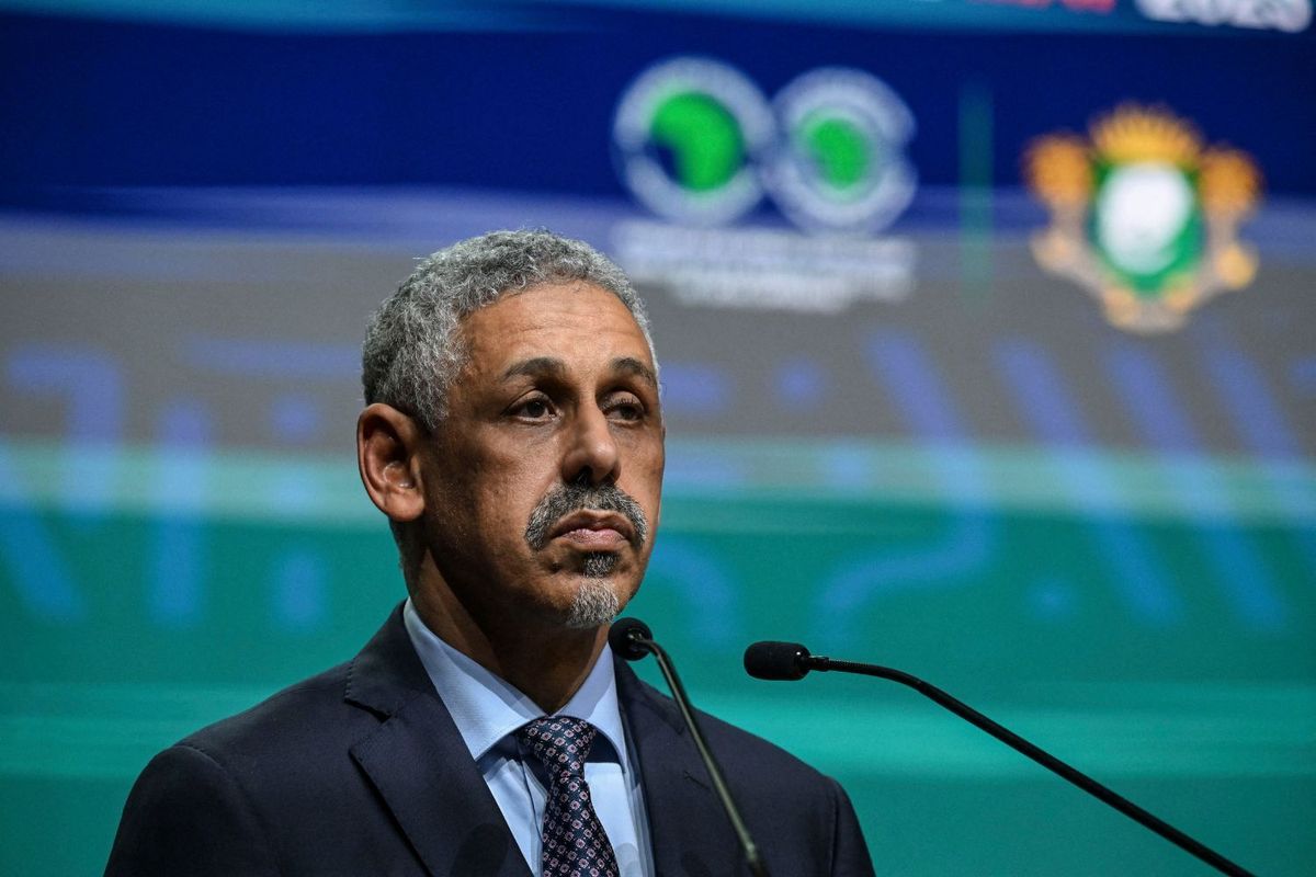 Mauritania's Sidi Ould Tah stands at a podium in front of a green and blue backdrop, wearing a dark suit and patterned tie.
