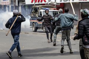 Men armed with sticks and clubs chase a protester in an attempt to stop him from demonstrating during clashes sparked by the death of Kenyan blogger Albert Ojwang, who died in police custody