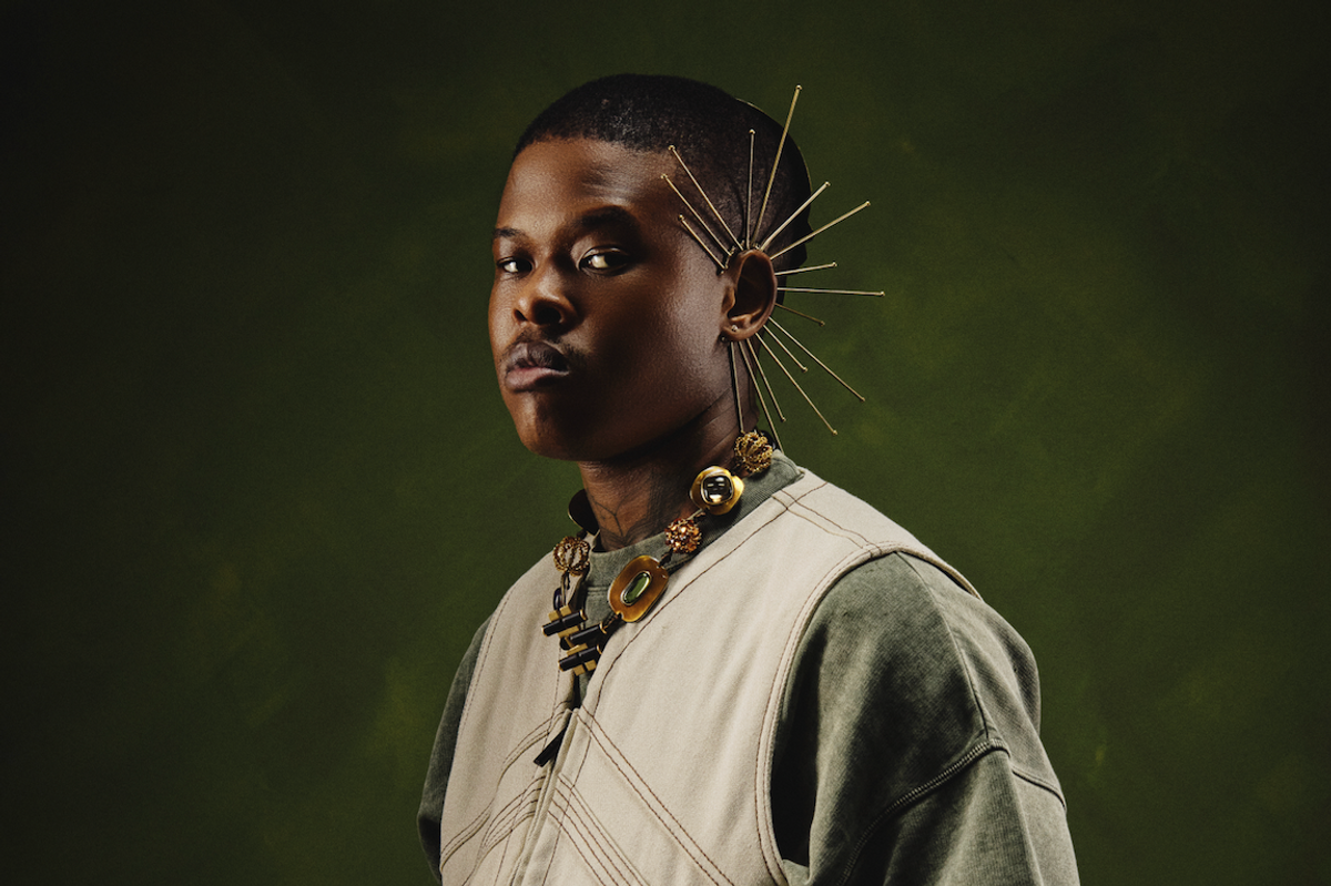 Nasty C poses for the camera, hands inside his jacket.