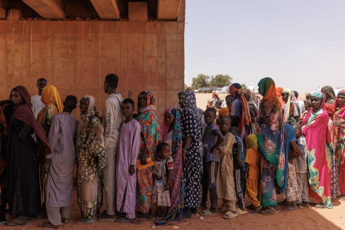 Newly arrived refugees fleeing fighting in Darfur have their documents processed in the shade of a partially finished bridge at the border of Sudan and Chad on April 20, 2024 in Adre, Chad.