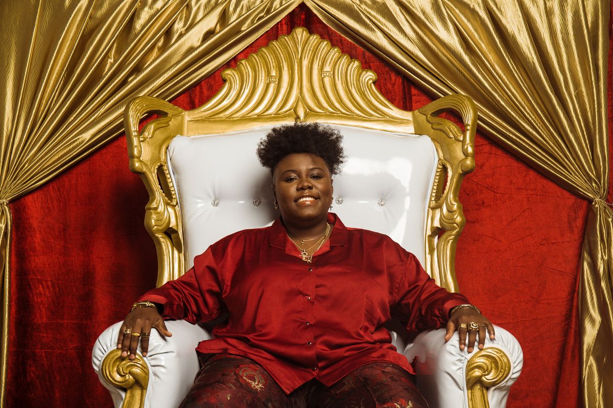 Nigerian singer Teni sits on a throne.