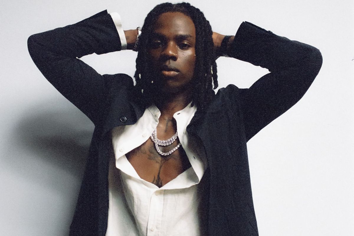 Nigerian superstar Rema posed up in a white shirt and a fitting black suit