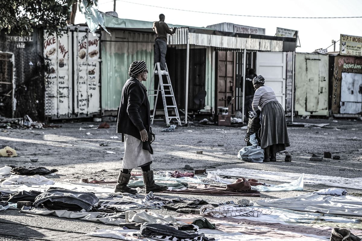 Older women laying out secondhand clothing on the ground
