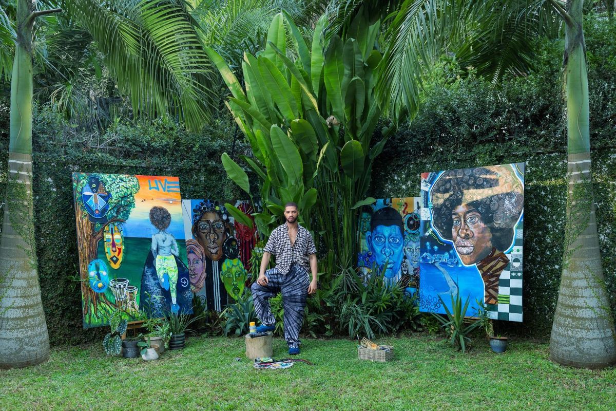 Osoranna Mojekwu stands next to four large paintings