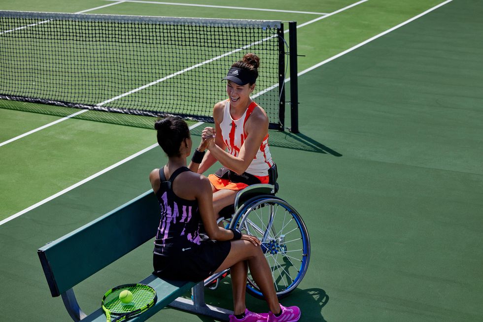 Paralympian Dana Mathewson in a wheelchair cheering with another tennis player