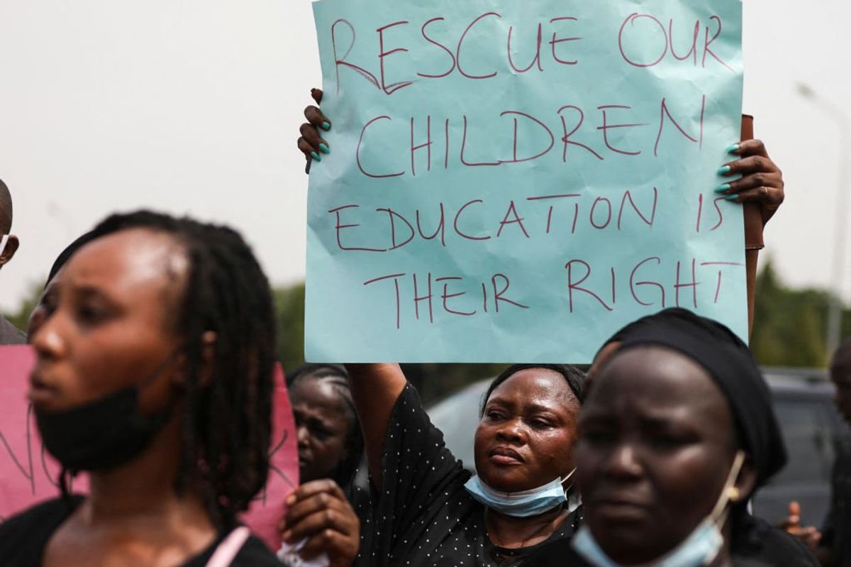 Parents and relatives of students from the Federal College of Forestry Mechanization in Kaduna who have been abducted, hold placards during a demonstration in Abuja on May 4, 2021.