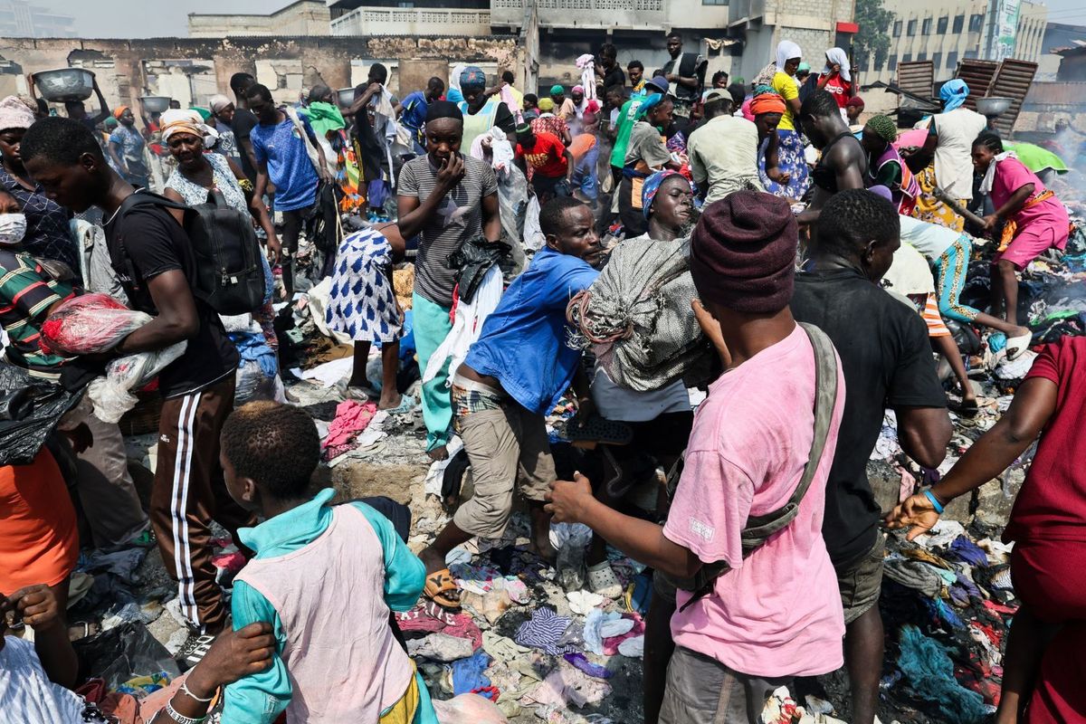 People try to salvage items from the burned-down secondhand clothing market at Kantamanto in Accra, Ghana, on January 2, 2025. The fire at the Kantamanto market began in the early morning hours, destroying a large part of the area and displacing thousands of traders.