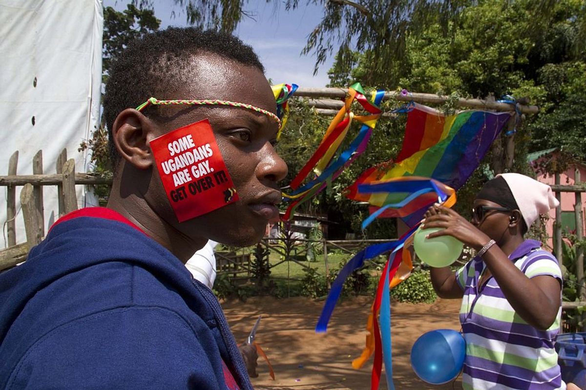 Photo of a Ugandan activist with a sticker that says, "Some Ugandans Are Gay. Get over it!"