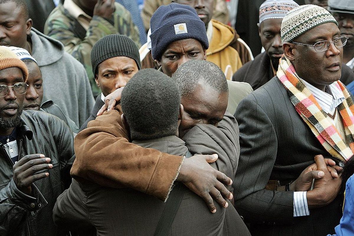 Pictured: Gambian community members comfort each other as they mourn those lost in the Jan 9th Bronx fire