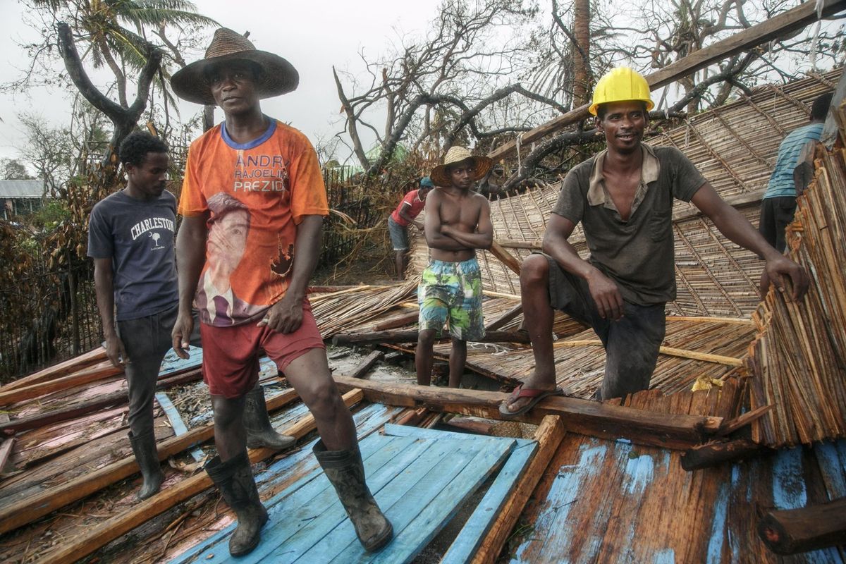 Residents pause while tryings to clear the rubble of a house after the passage of cyclone Batsirai, in the Tanambao district on February 8, 2022 in Mananjary, Madagascar.