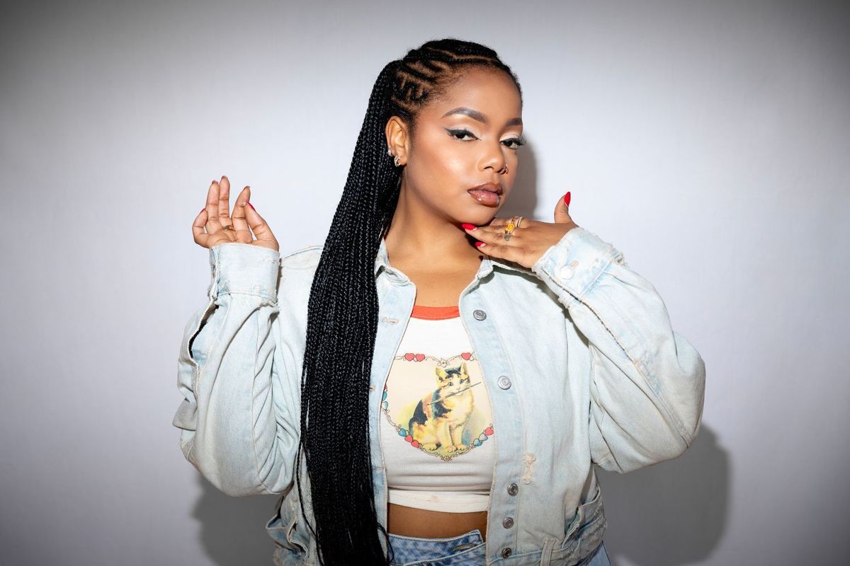 South African artist Shekhinah poses in a promotional image wearing a denim jacket.