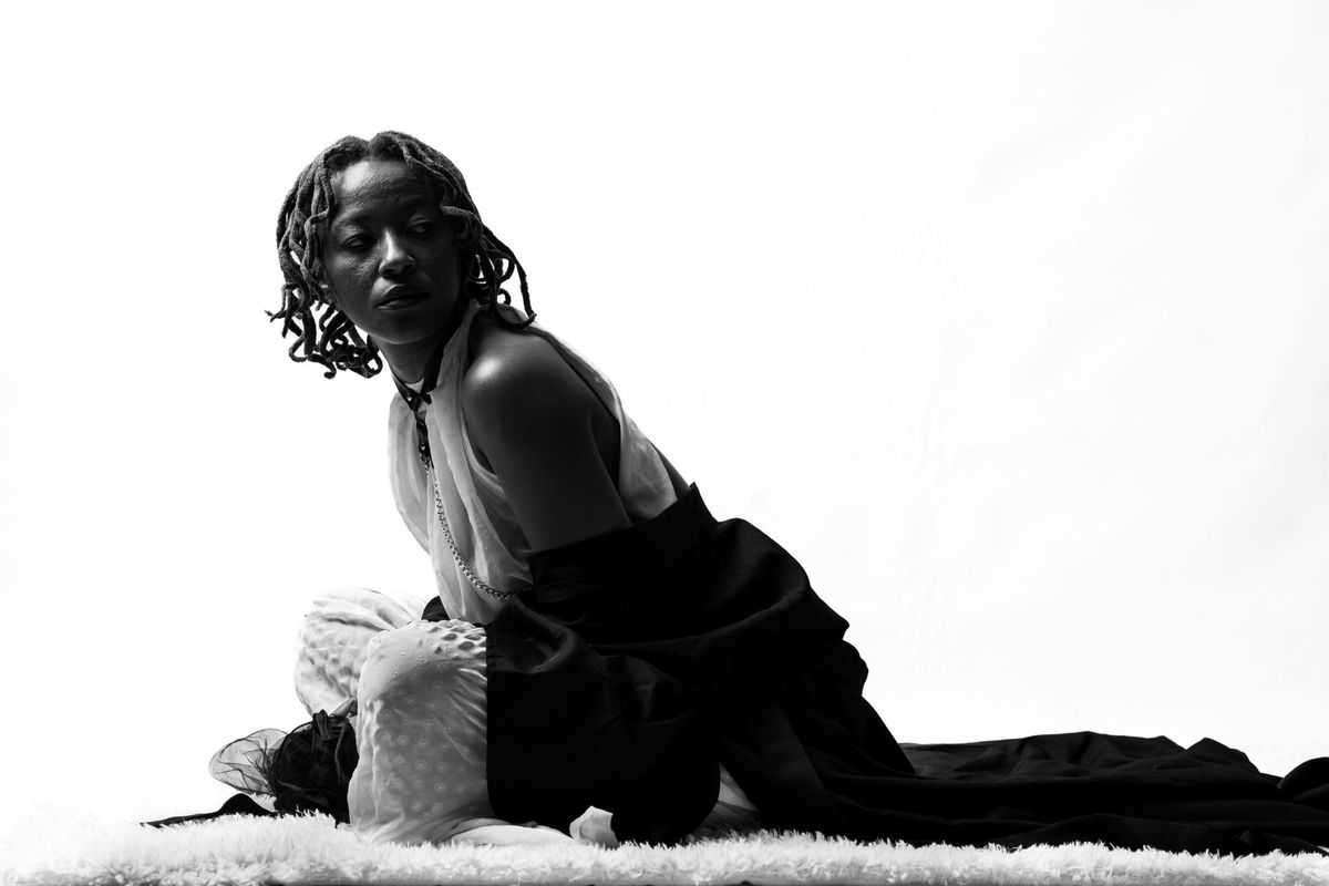 South African artist Yugen Blakrok poses in a black-and-white promotional photo.