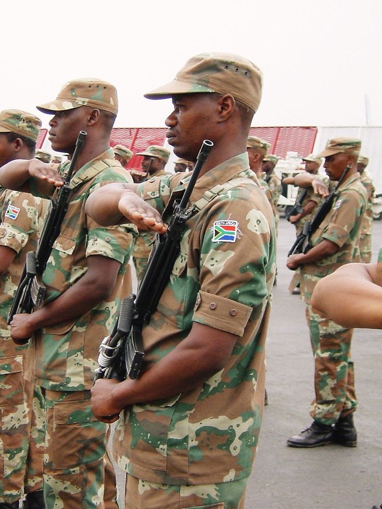 ​South African troops, serving as peacekeepers with the African Union Mission in Burundi salute the arrival of Major General Siphiwe Nyanda, chief of the South African National Defence Force, Bujumbura, Burundi, 27th August 2003