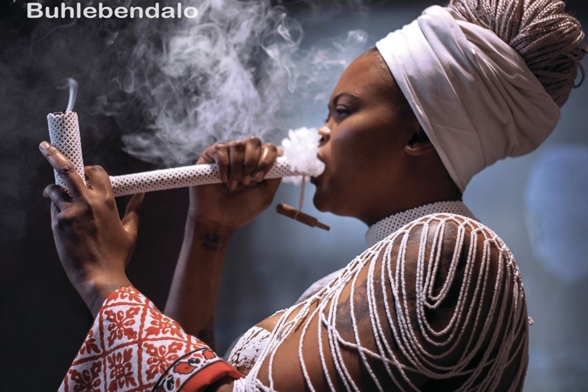 ​The cover for Buhlebendalo's new album 'Chosi': floating text over an image of Buhlebendalo smoking pipe. 