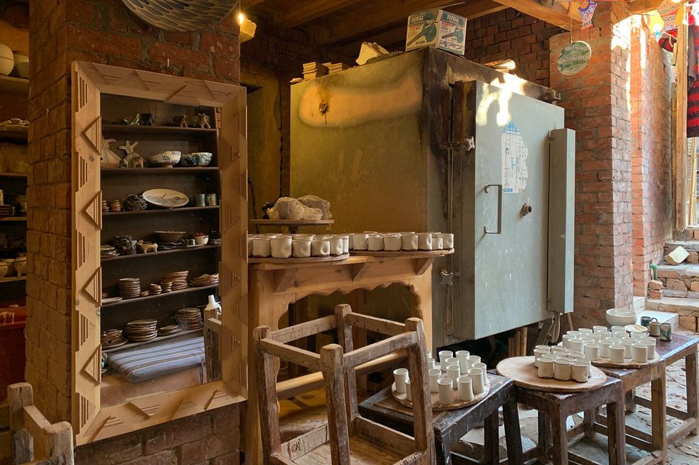 The inside of Ibrahim Samir's pottery workshop is filled with mugs and cups that students are working on. 