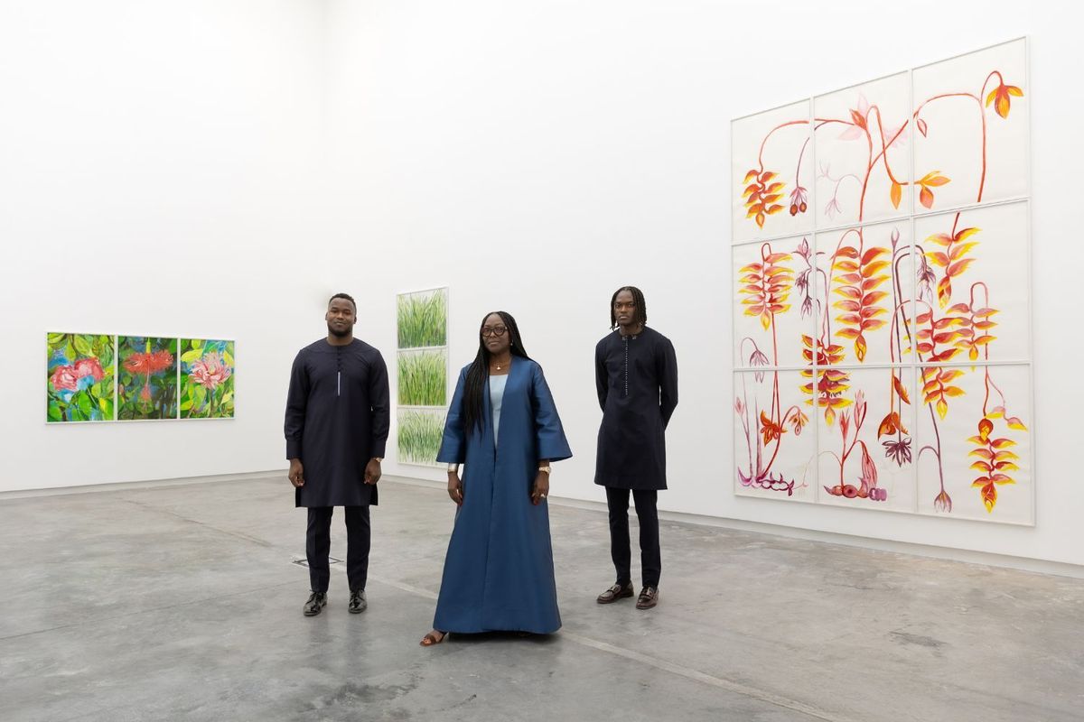 The Mintah family poses for a picture, standing side by side in a white walled gallery space.