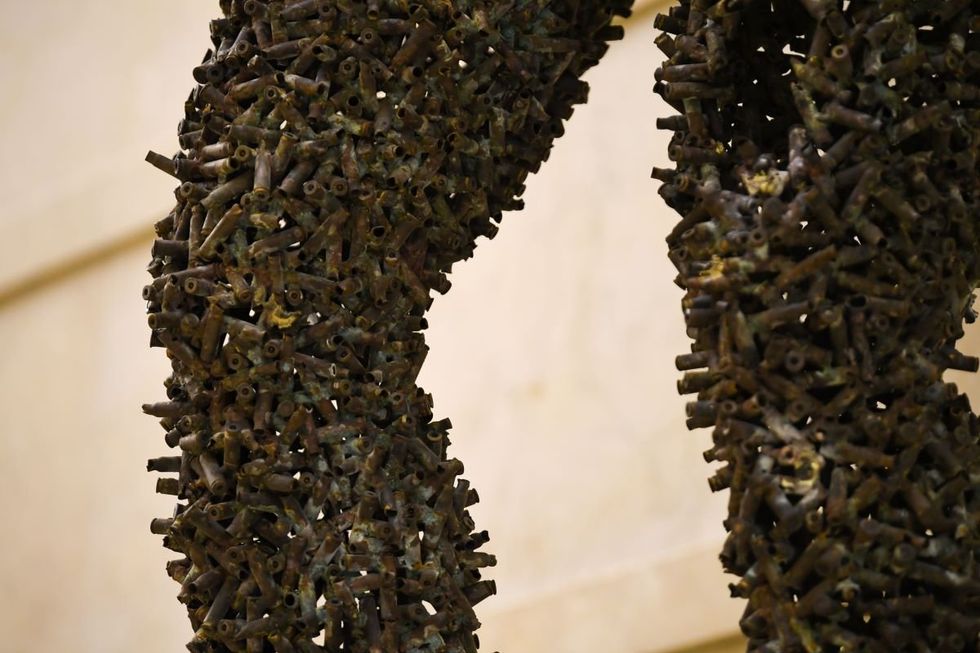 This picture shows the legs of a giant sculpture made with cartridges by the Congolese artist Freddy Tsimba, inaugurated at the Palais Chaillot, in Paris, on December 6, 2018 as part of the 70th anniversary of the Declaration of Human Rights.