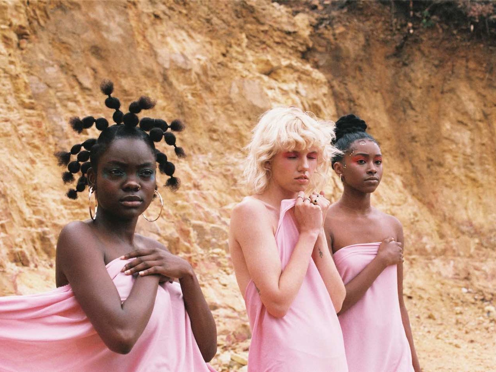 Three women all dressed in pink in a desert on-set for Sam Turpin's latest music video. 