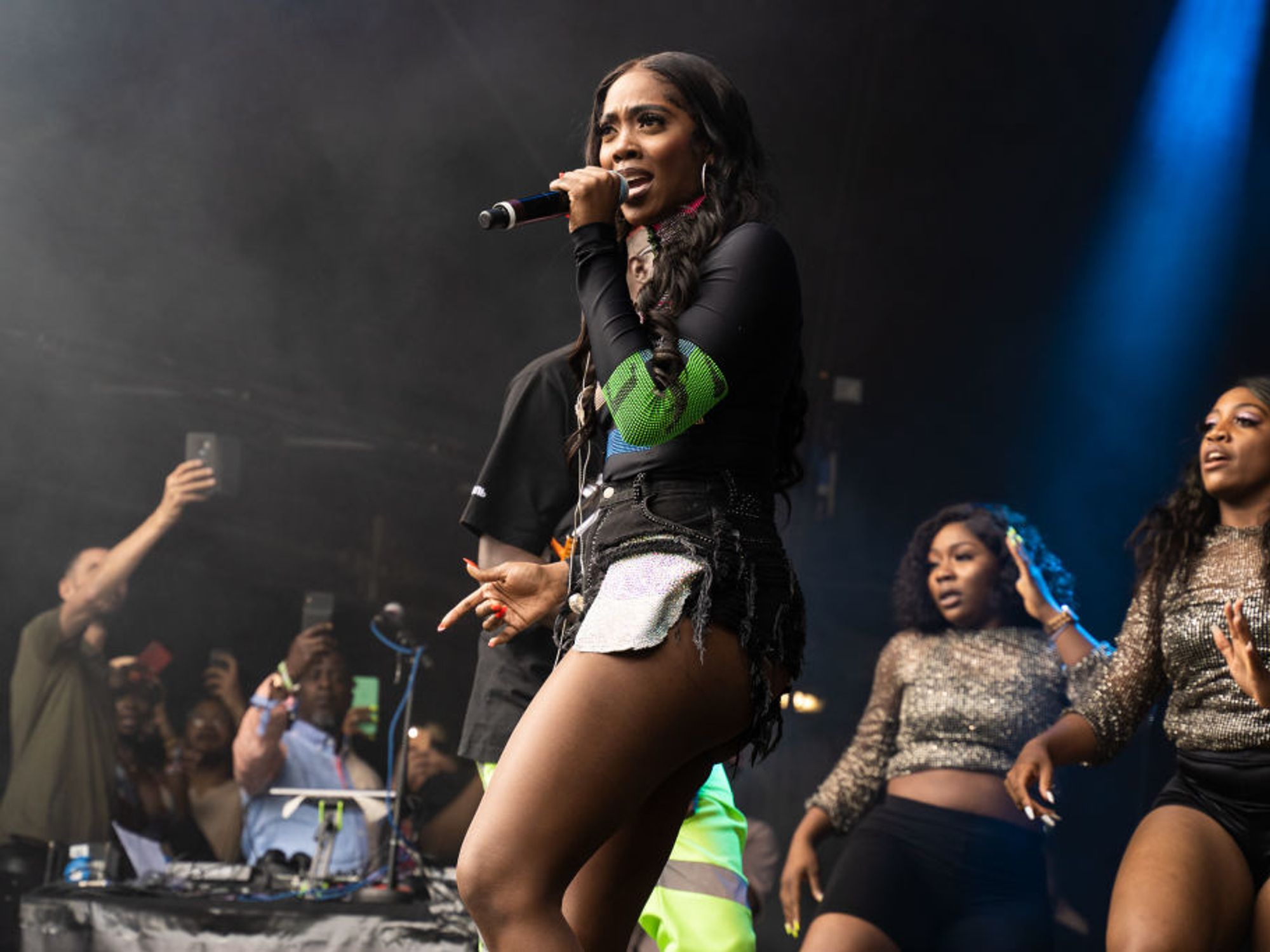 Tiwa Savage on stage with two dancers behind her. 