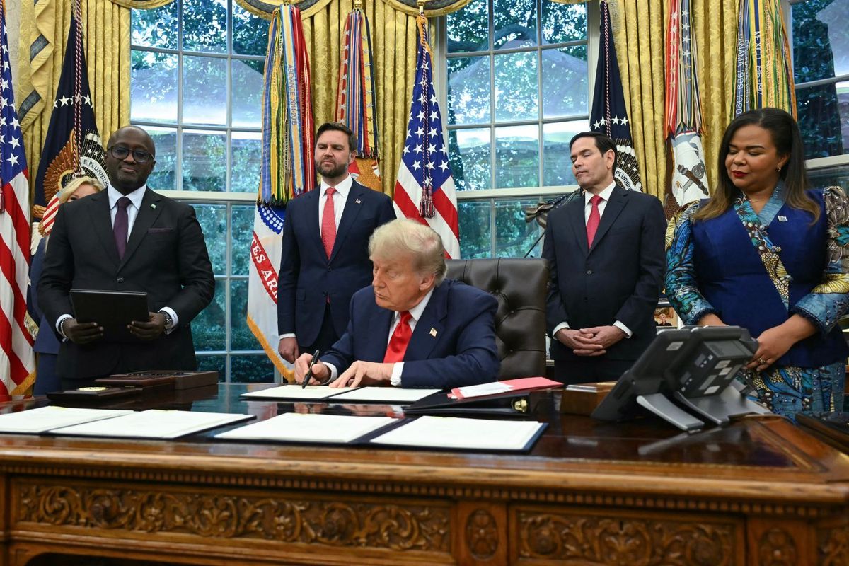 Trump signs a letter in the Oval Office ceremony with Congo Foreign Minister Therese Kayikwamba Wagner, Rwandan Foreign Minister Olivier Nduhungirehe, US Vice President JD Vance, and US Secretary of State Marco Rubio looking on.