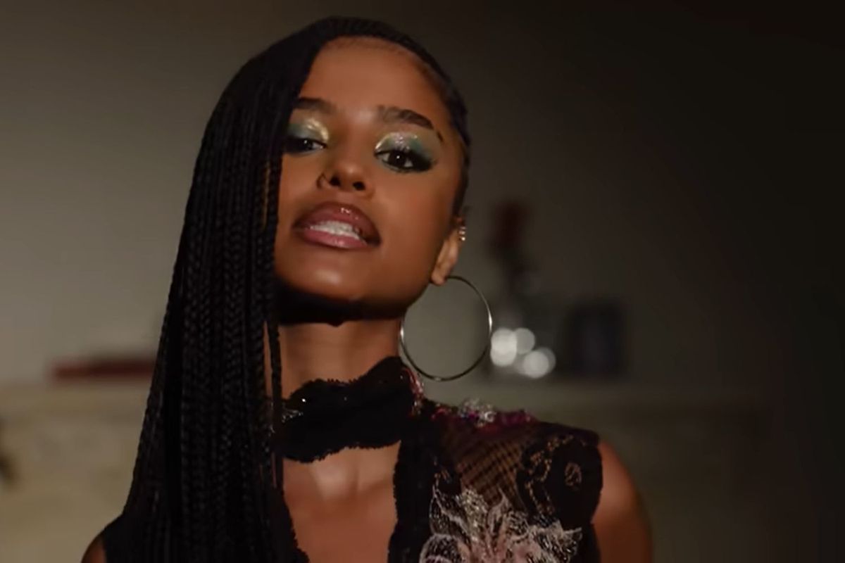 Tyla looks into the camera, rocking long braids and silver jewelry
