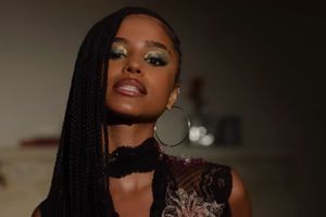 Tyla looks into the camera, rocking long braids and silver jewelry 