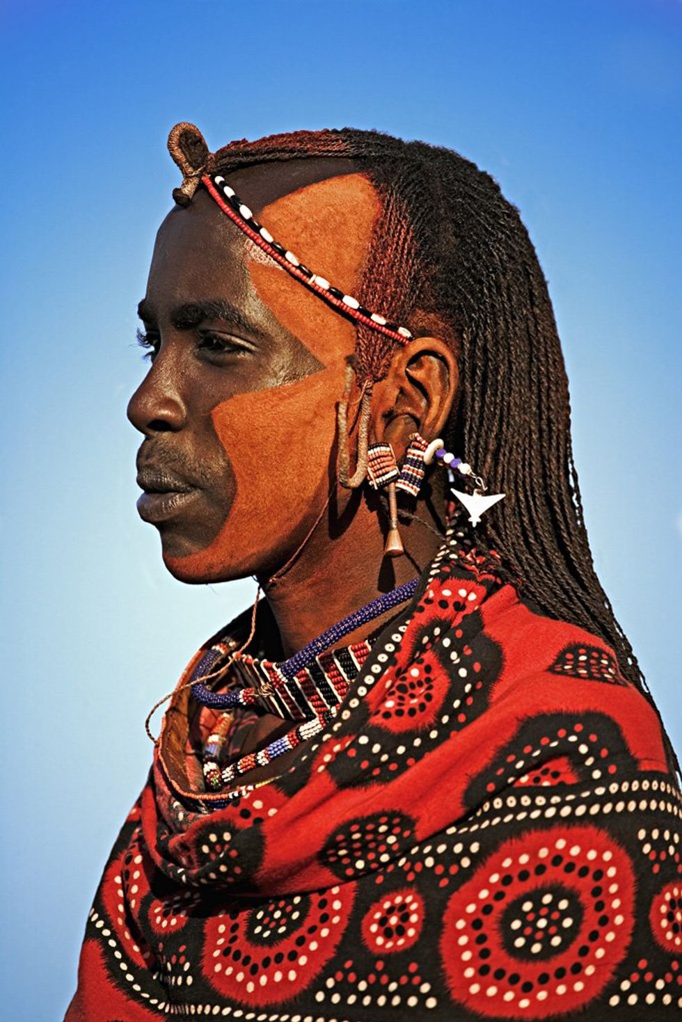 \u200bMaasai people. Men commonly mix ochre and oil to color their hair and skin red. Near Amboseli National Park, Kenya