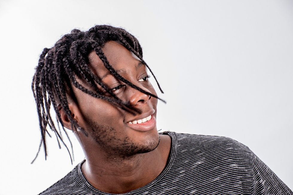 \u200bYoung African man from Sierra Leone dancing with plaited hair.