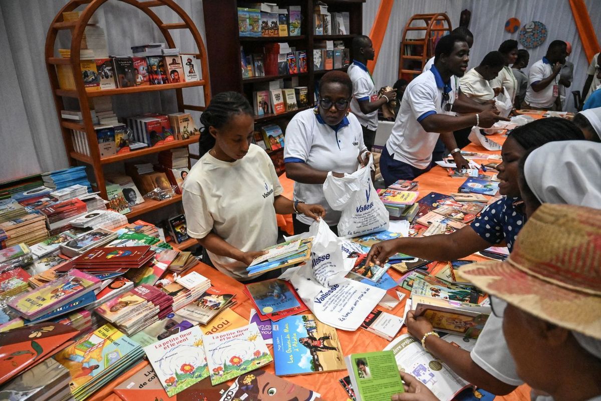 Visitors look at books at a stand during the International Book Fair at the Abidjan exhibition center in the commune of Port-Bouet in Abidjan on May 15, 2024.